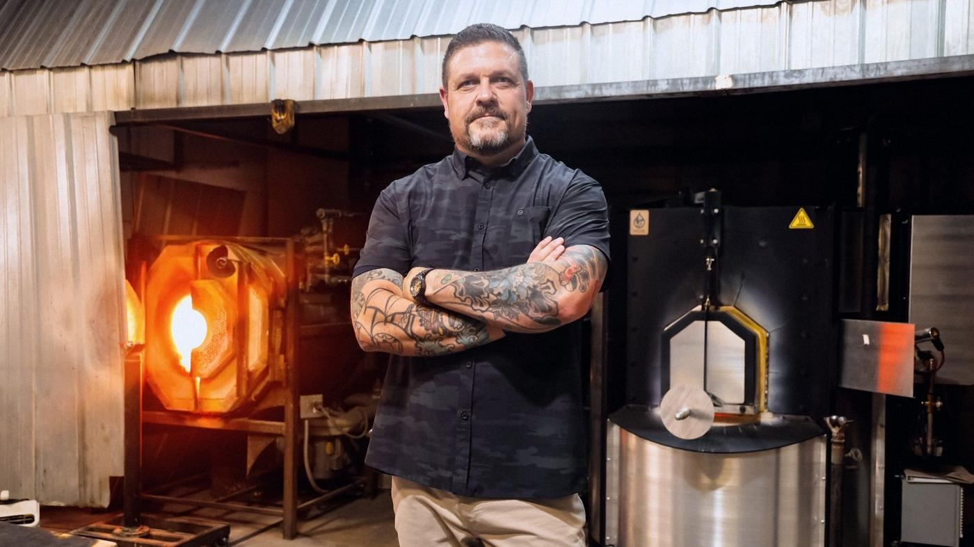 Steve Baumgartner in front of a glowing furnace